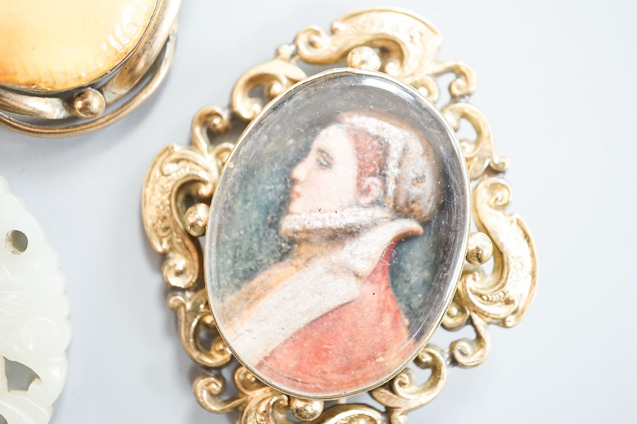 A 19th century gilt metal mounted brooch, with inset oval painted wax bust of a lady to dexter, 60mm and four other items including a 9ct mounted oval tiger's eye quartz pendant.